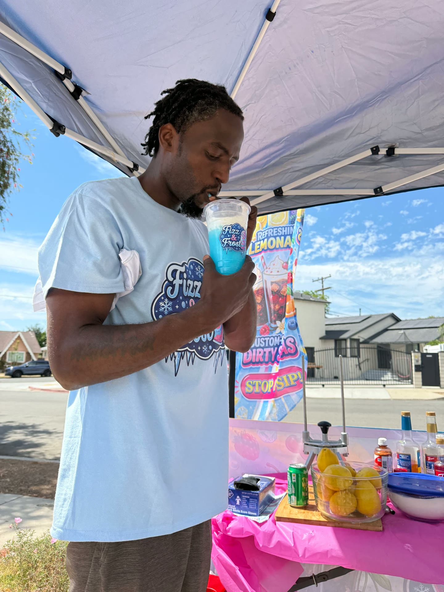 Customer sipping a blue frozen drink under the Fizz & Frost tent