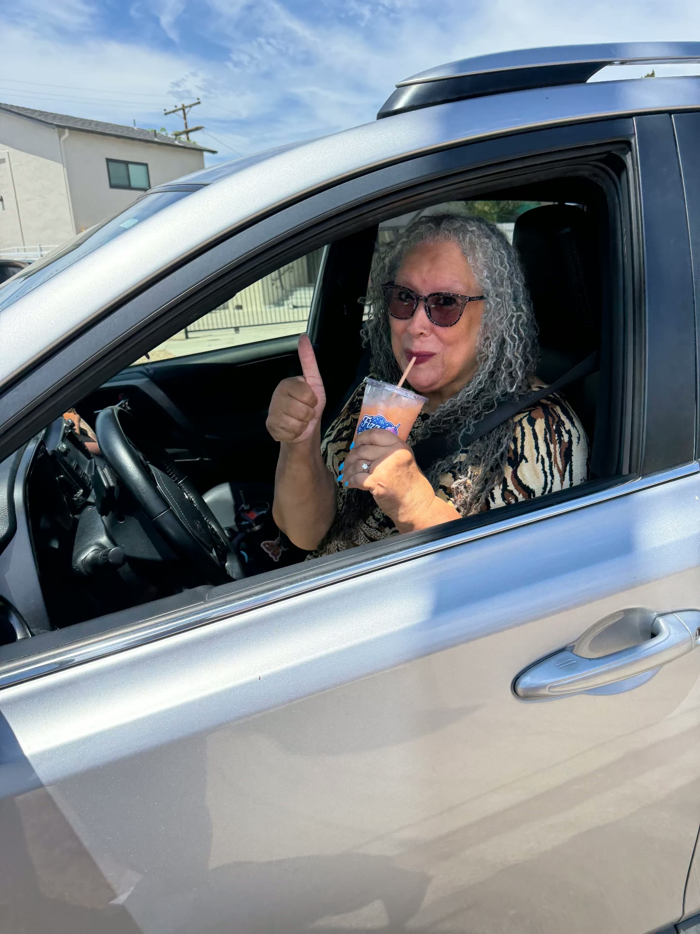 Customer giving a thumbs up while sipping a Fizz & Frost drink